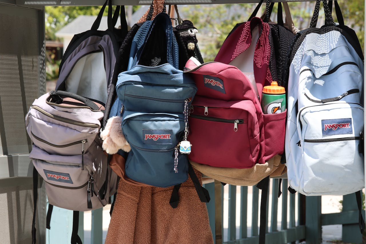 services-04 A collection of colorful backpacks hanging outside on a sunny day. Perfect for back-to-school themes.