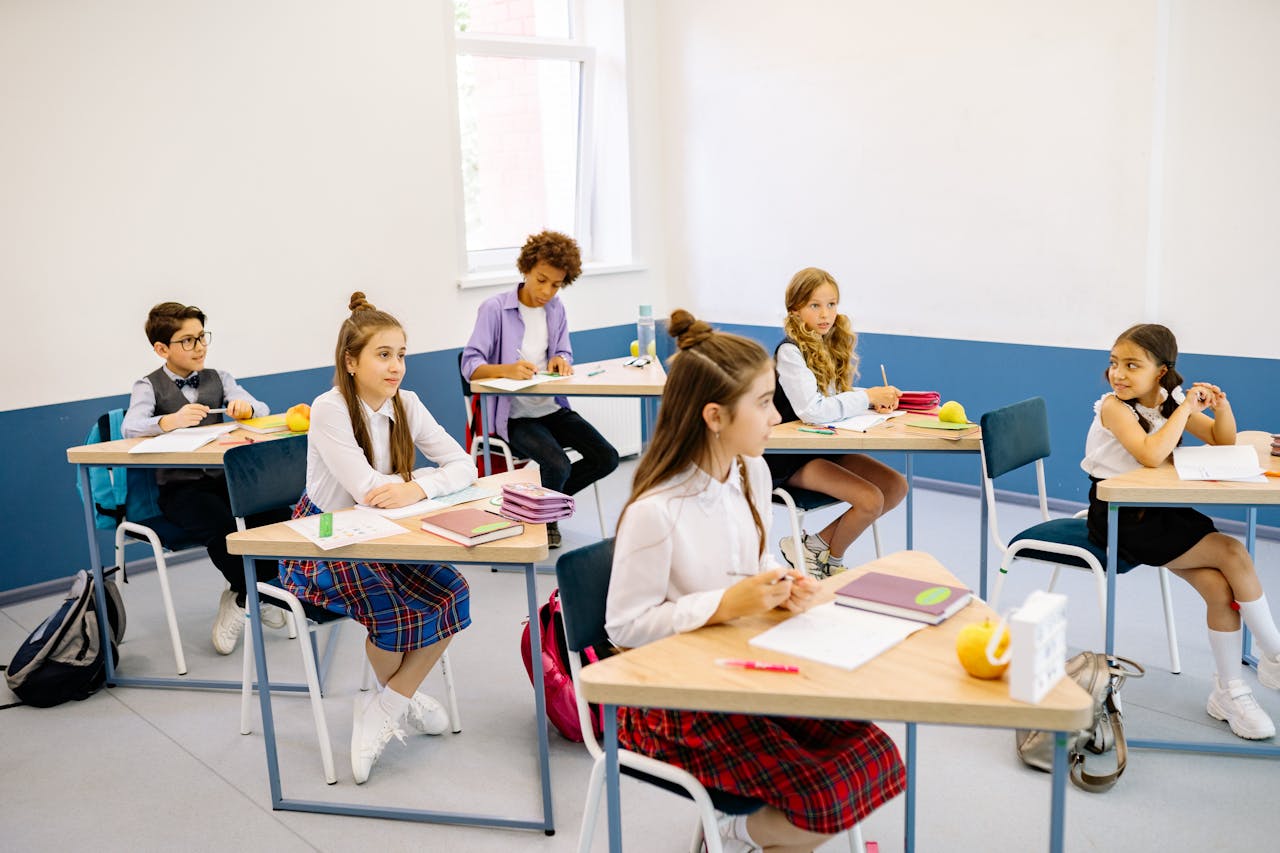 Students learning in a bright, diverse classroom setting, engaged and attentive.